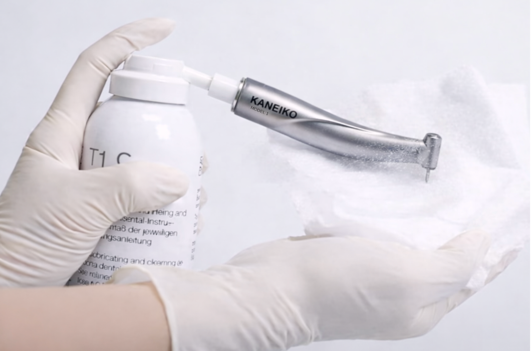 Working on proper lubrication maintenance for Kaneiko handpiece product with a gloved hand holding it against a white background